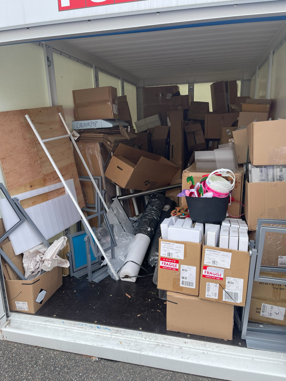 Packed storage unit before cleanout showing boxes and miscellaneous items