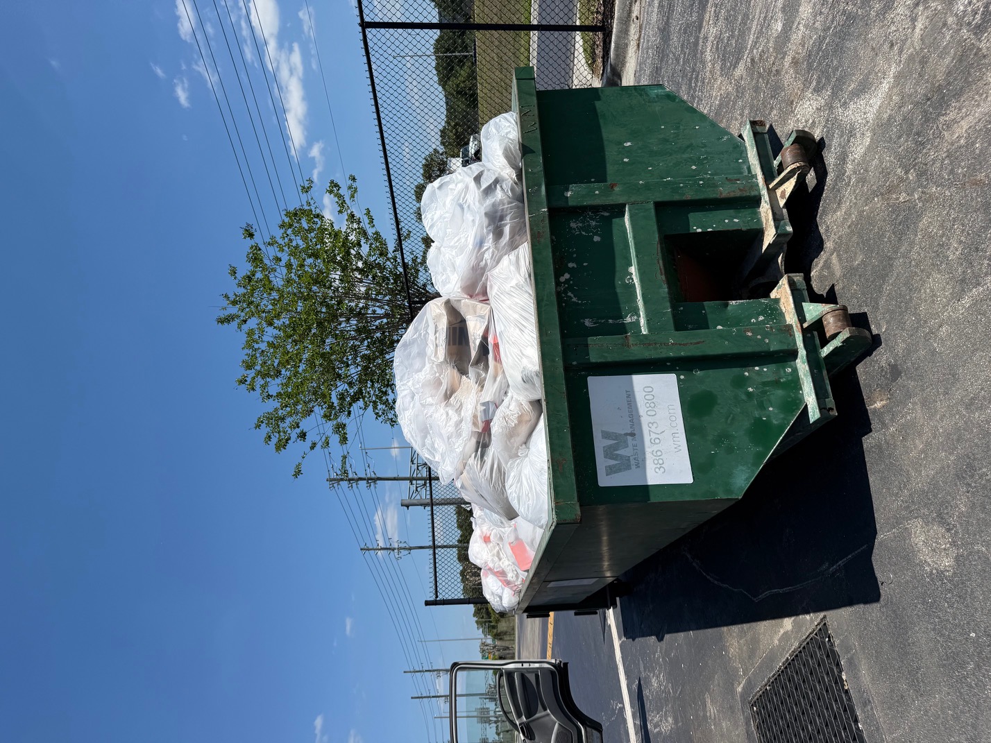 Large dumpster filled with bagged items showing our volume capacity